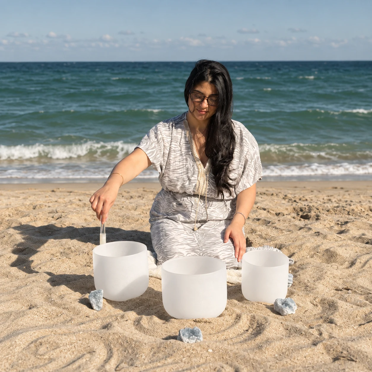 Sylvia Lee playing crystal singing bowls beside the sea